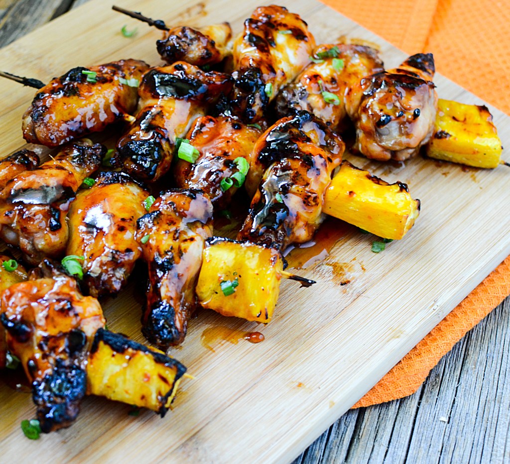 30 Best camping meals ever! Chicken wings on skewers with pineapple chunks on a wooden cutting board