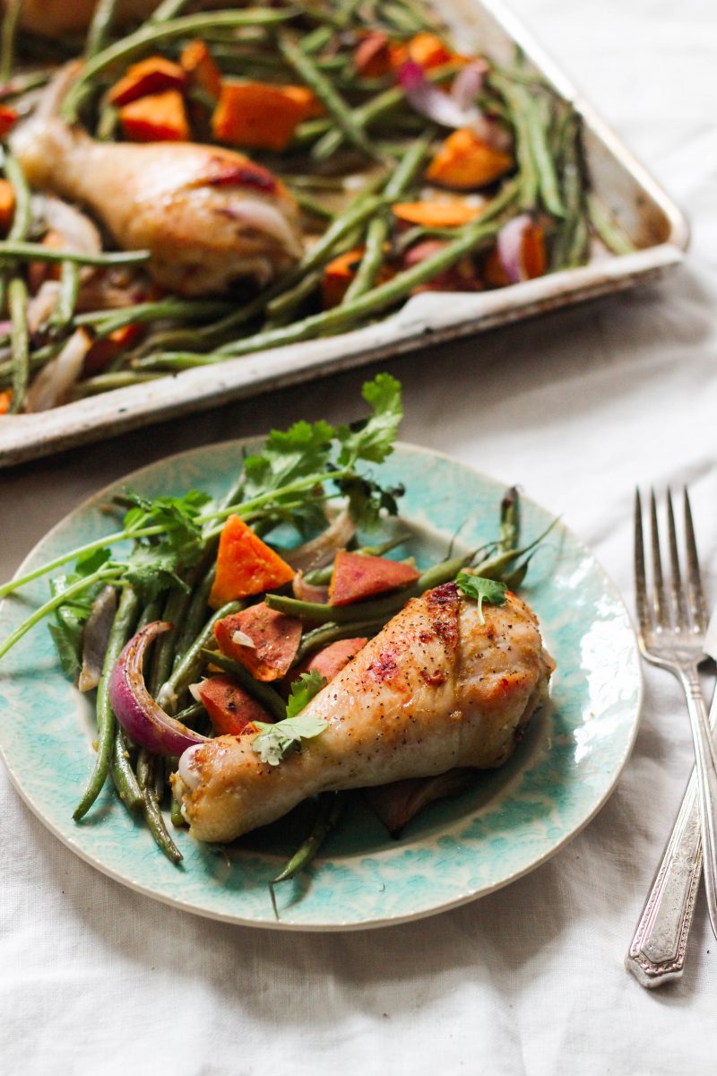 Chicken on a plate with greens, red onion and other vegetables. Sheet Pan Dinner Options.